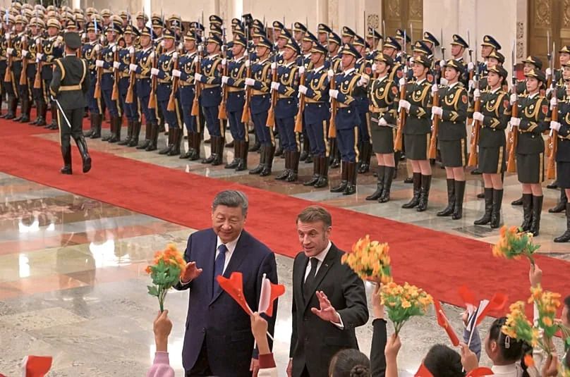 France's President Emmanuel Macron gestures towards children next to China's President Xi Jinping at the Great Hall of the People in Beijing, 4 December, 2025