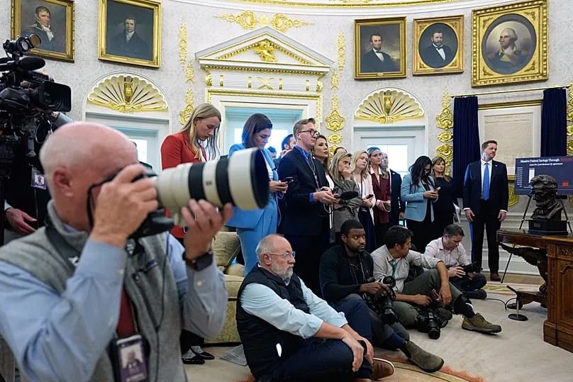 Reporters and photographers work as President Donald Trump speaks in the Oval Office of the White House, Thursday, Oct. 16, 2025, in Washington.
