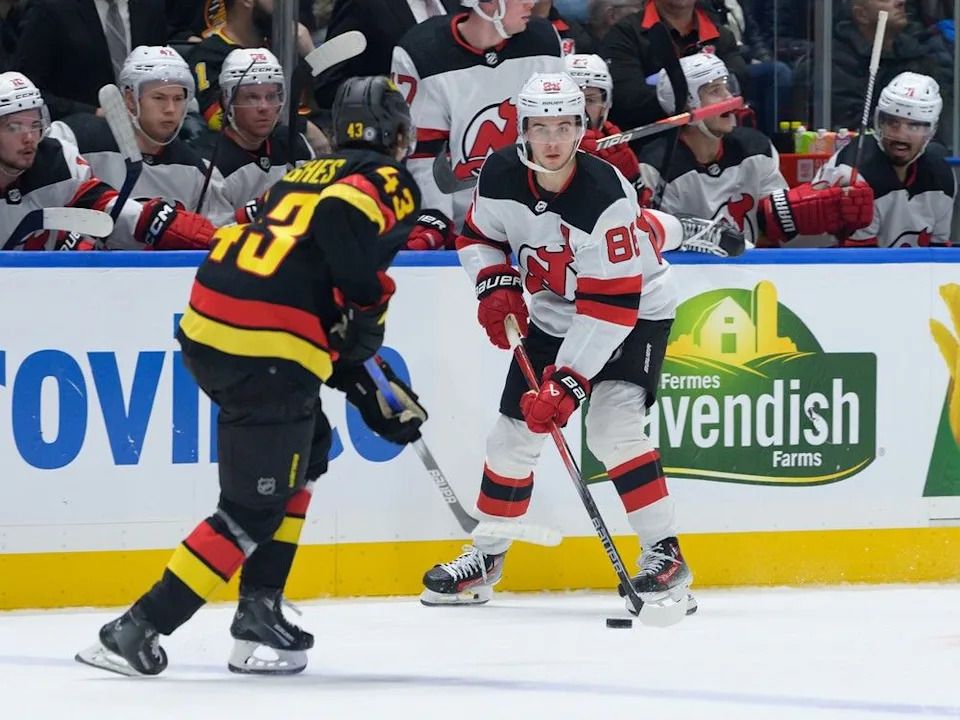 Quinn Hughes of the Canucks defends brother Jack Hughes of the Devils on Dec. 5, 2023 at Rogers Arena.