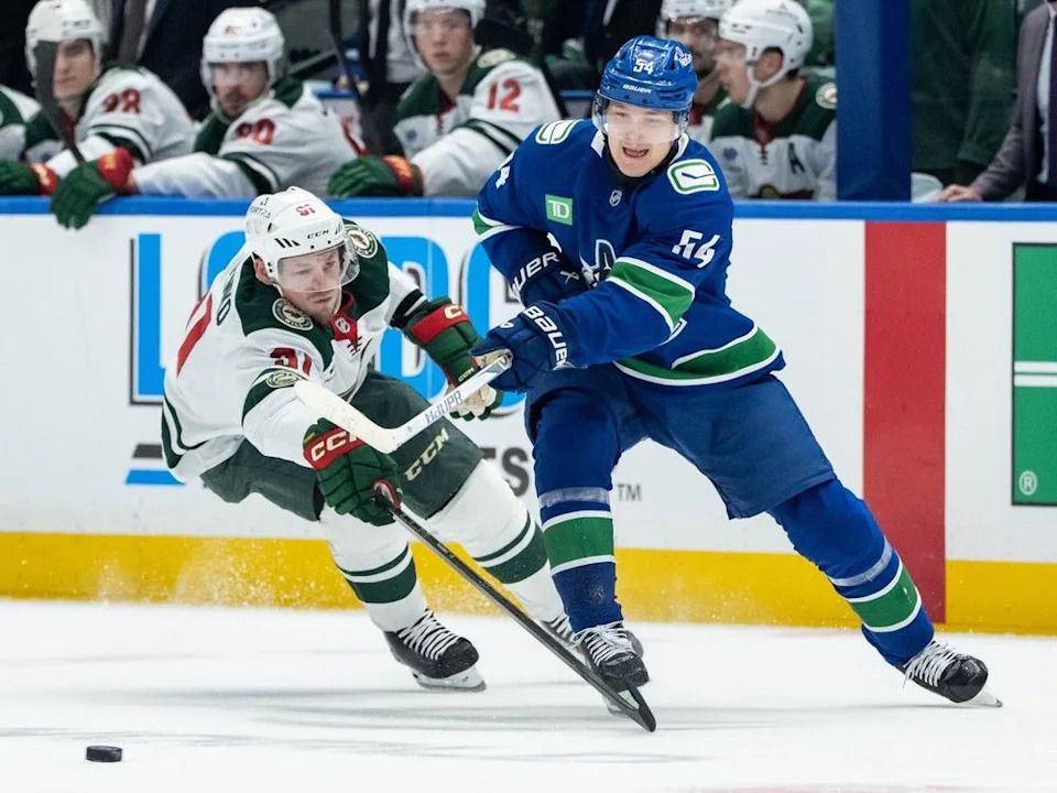 Canucks centre Aatu Raty and Wild winger Vladimir Tarasenko battle for puck Saturday at Rogers Arena.