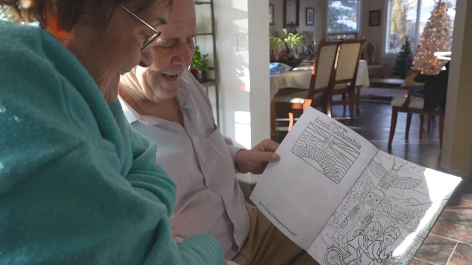 Tanya (Mrs. Claus) and Bev Cuckow (Santa Bevy) look through a copy of their Christmas-themed custom colouring book. Santa Bevy says he hopes to hand out more than 2,000 this year.