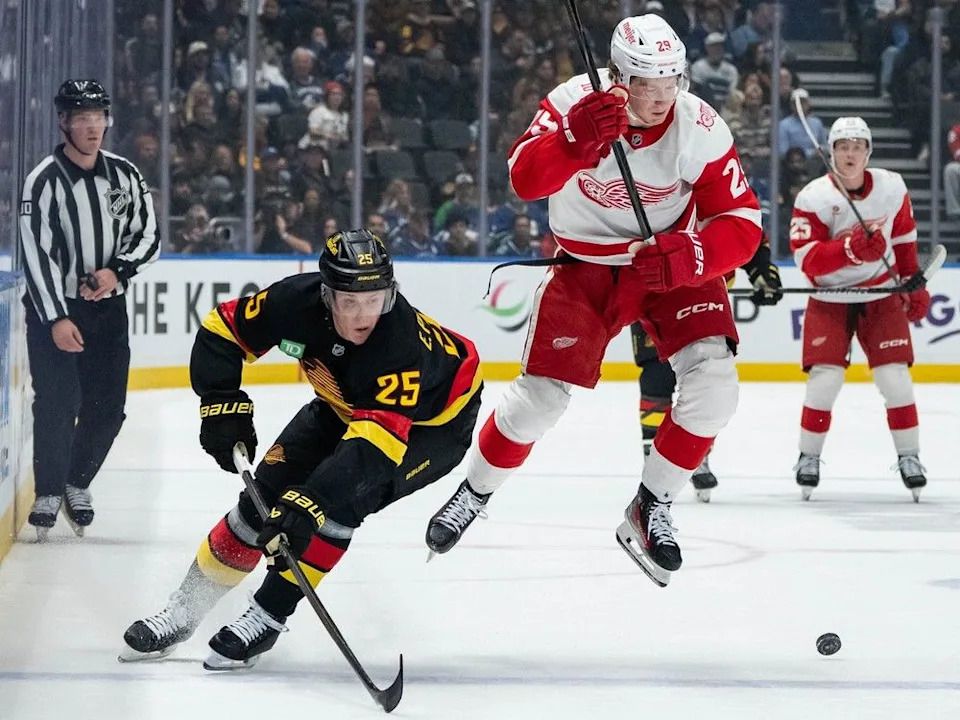 Detroit Red Wings’ Nate Danielson (29) jumps to avoid Elias Pettersson (25) as they vie for the puck during the first period