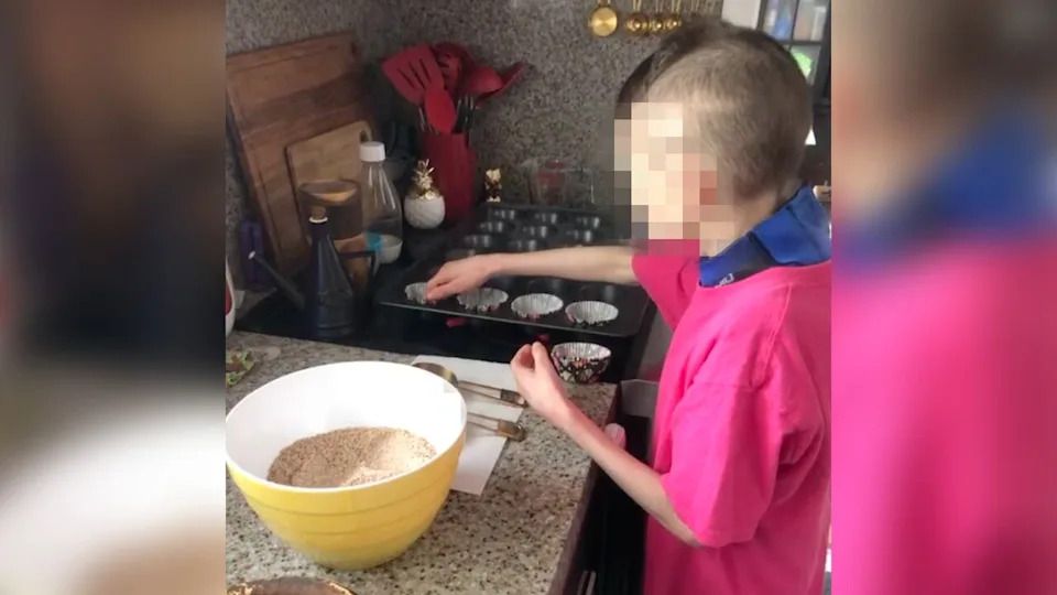 L.L. wore a wetsuit most of the time and was severely malnourished before he died. He's shown here in Cooney and Becky Hamber's kitchen on Aug. 22, 2022. CBC has blurred his face to protect his identity.