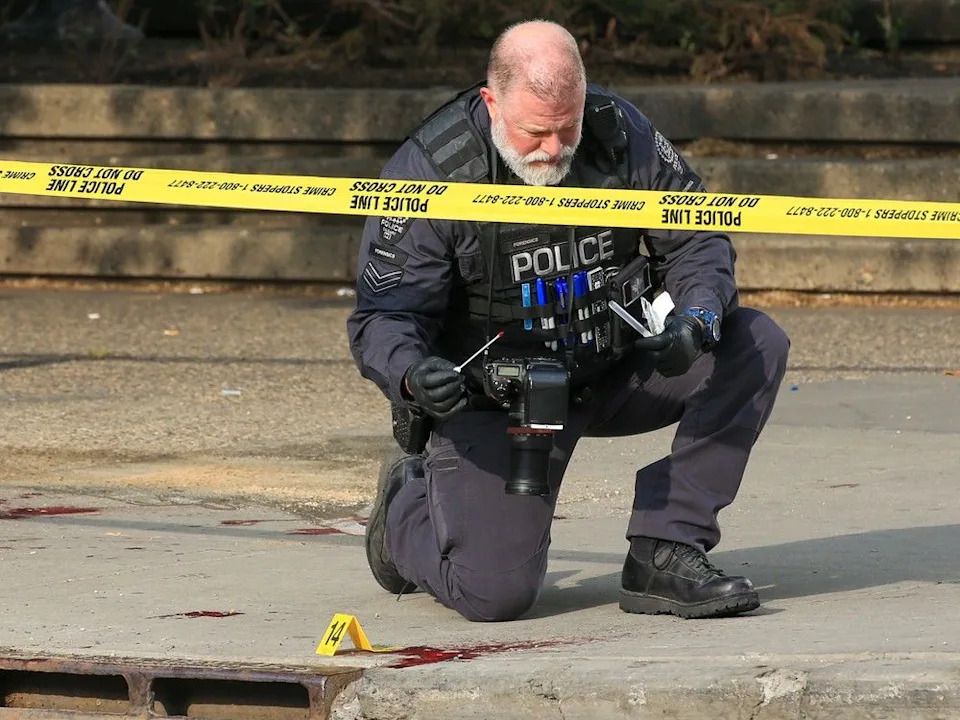 A Calgary police forensics officer takes a blood sample from the scene of a fatal attack at Olympic Plaza on Thursday, May 25, 2023.