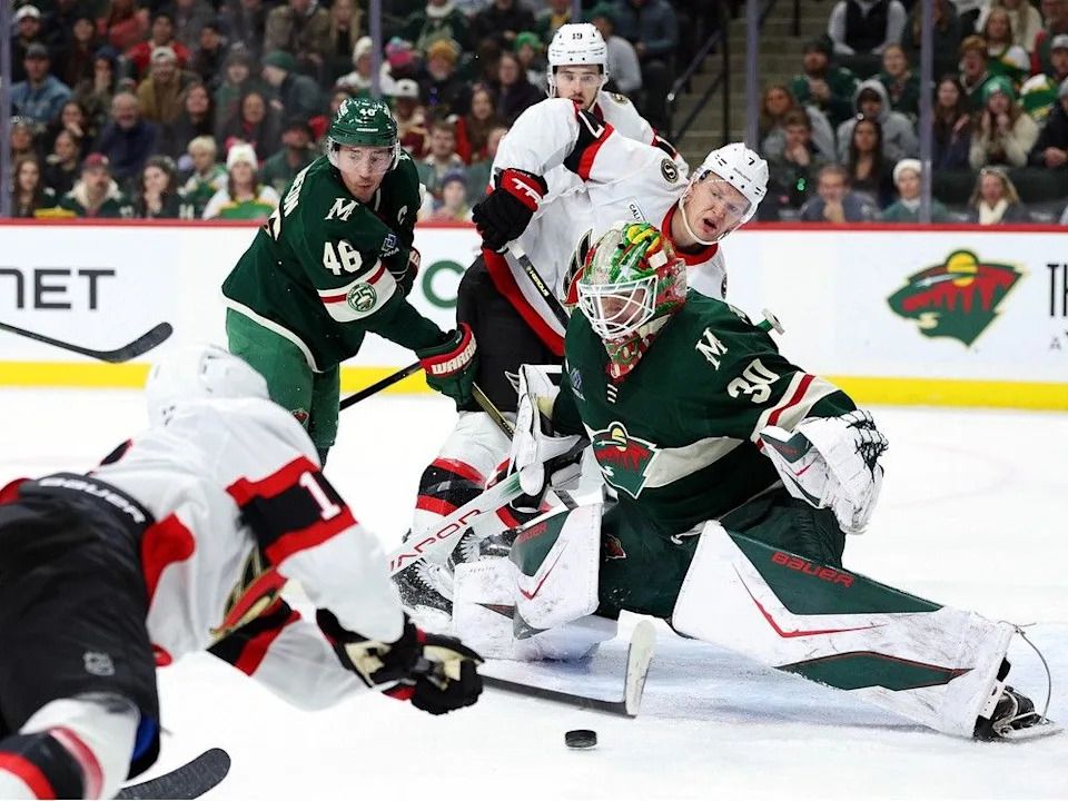 Tim Stützle, left, of the Senators scores a power-play goal against Jesper Wallstedt of the Wild in the second period on Saturday afternoon.