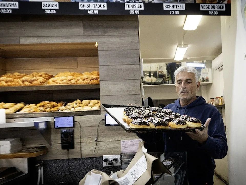 Falafel St. Jacques owner Ronen Baruch brings out a tray of sufganiyot.
