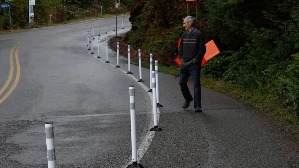 Steven Earle walks along the newly cordoned off pedestrian path leading into the ferry terminal on Gabriola Island, B.C., after an unknown individual installed the delineators in the middle of the night last week.