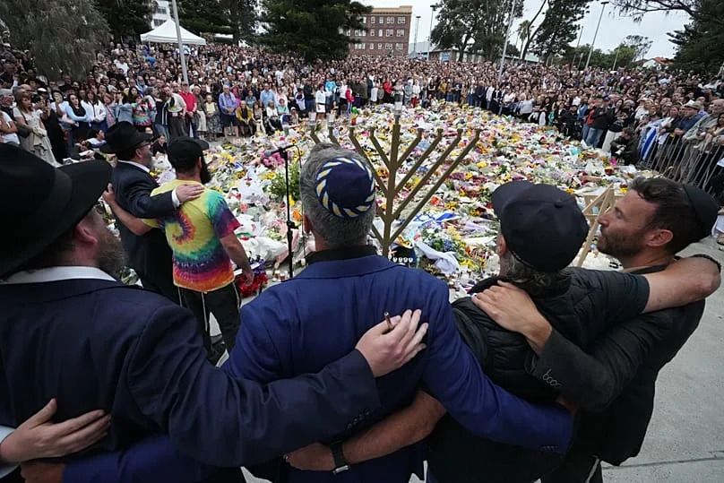 Mourners gather at a menorah lighting ceremony at a floral memorial for victims of Sunday's shooting at the Bondi Pavilion at Bondi Beach, 16 December, 2025