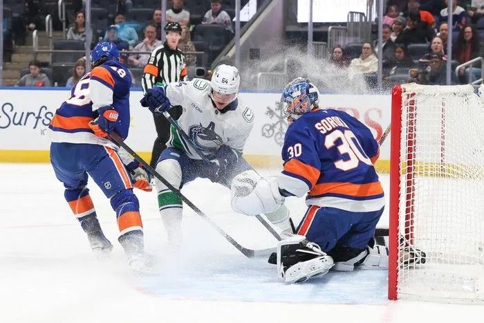 David Kampf of the Vancouver Canucks skates in front of Ilya Sorokin of the New York Islanders during the first period of an NHL game at UBS Arena on Dec. 19, 2025, in Elmont, New York.