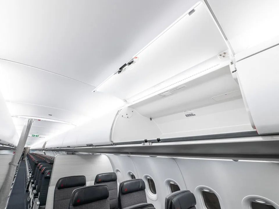 An empty overhead bin in the economy section of an Air Canada Airbus 321.