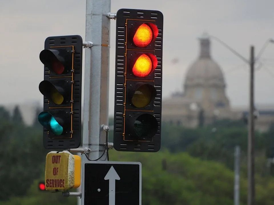 The Alberta legislature is framed by traffic lights near Edmonton’s Walterdale Bridge in July 2014.