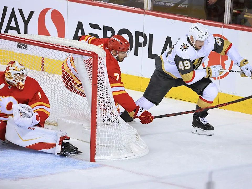 Calgary Flames defenceman Kevin Bahl and Vegas Golden Knights forward Ivan Barbashev race behind the net during NHL action at the Scotiabank Saddledome in Calgary on Saturday, Dec. 20, 2025.