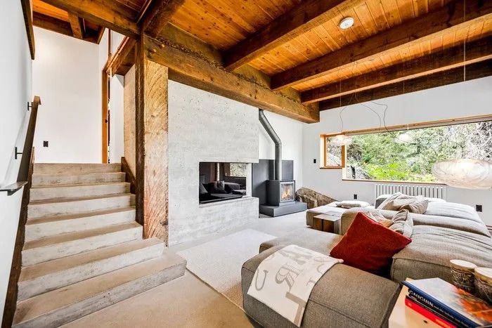 Massive century-old, rough-cut timber beams reclaimed from a warehouse on Vancouver Island add warmth and history to the modern home.