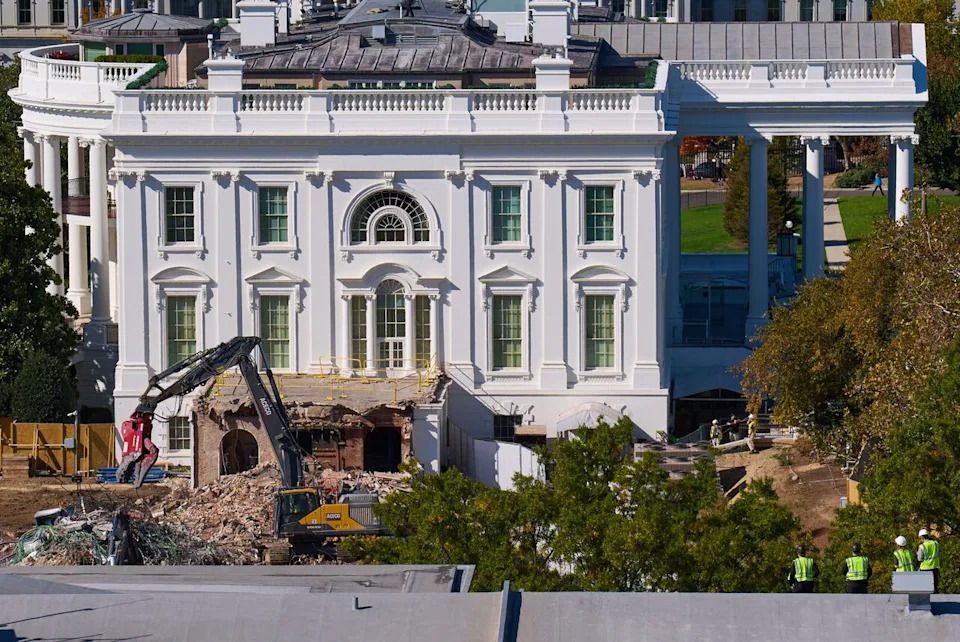 Construction workers, bottom right, atop the U.S. Treasury, watch as demolition continues on the East Wing of the White House to make room for a new ballroom, in Washington, Oct. 22, 2025.