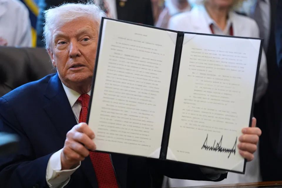 President Donald Trump displays an executive order reclassifying marijuana as a less dangerous drug in the Oval Office of the White House, Thursday, Dec. 18, 2025, in Washington.