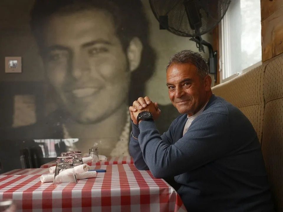 Richard Valente sits inside Roberto Pizza, named for his late brother, whose portrait adorns one wall.