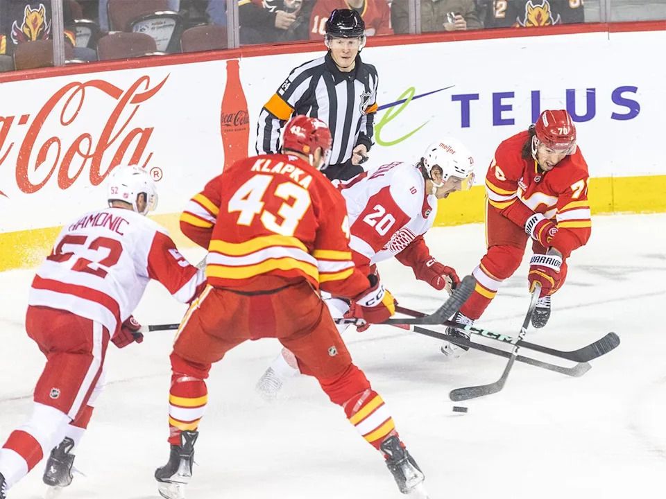 Calgary Flames left winger Ryan Lomberg and right winger Adam Klapka make a play on the Detroit Red Wings during the first period at the Scotiabank Saddledome on Wednesday, Dec. 10, 2025.