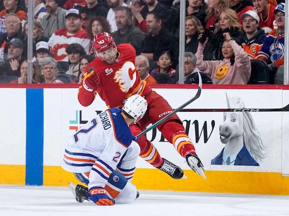Adam Klapka #43 of the Calgary Flames and Evan Bouchard #2 of the Edmonton Oilers collide during the first period at the Scotiabank Saddledome on Dec. 27, 2025 in Calgary, Canada.