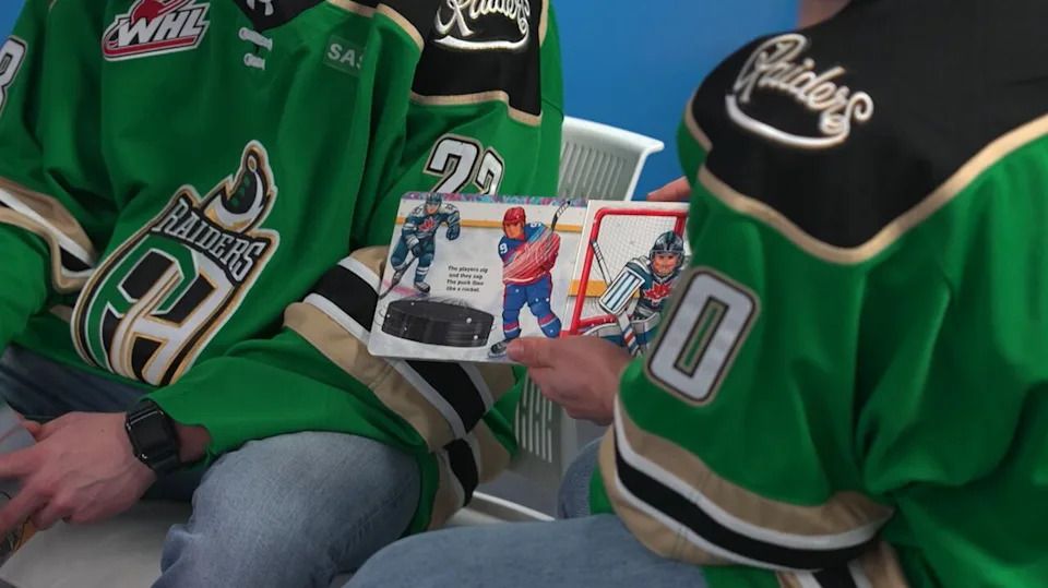 Prince Albert Raiders hockey players read books to children at a local public library.