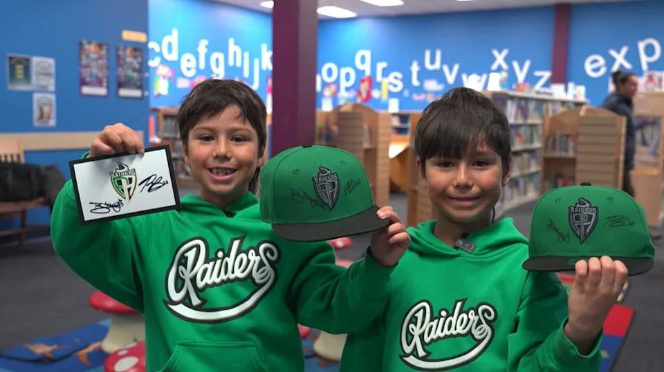 Riley Penner's twin sons show off their signed merchandise.