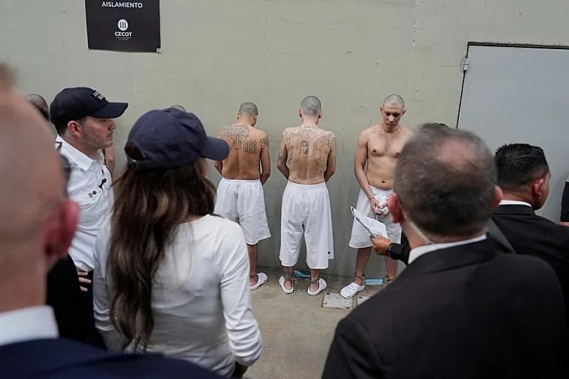 Shackled prisoners stand against a wall as Homeland Security Secretary Kristi Noem tours the Terrorism Confinement Center in Tecoluca, Salvador, March 26, 2025. (AP Photo)