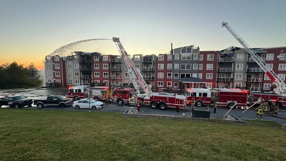 Firefighters douse hotspots at an apartment building on Hanwell Drive in Middle Sackville, N.S., that caught fire early on Monday, Sept. 15, 2025.
