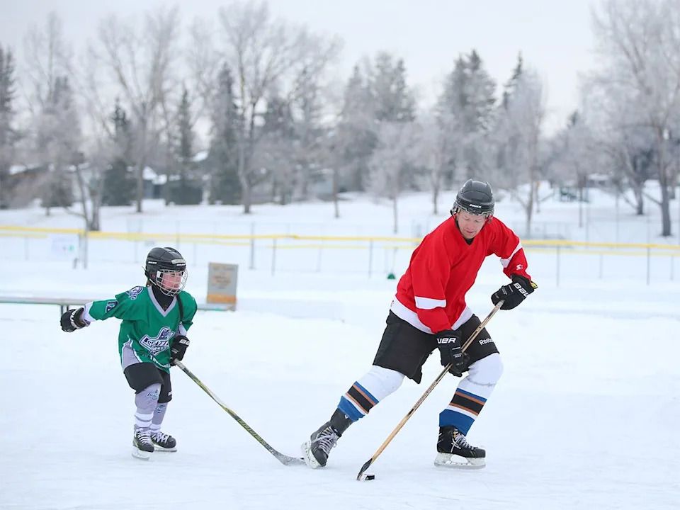Patrick Lewis and his son Henry, 8, play outdoor hockey at Triwood Community Association in northwest Calgary on Friday, Jan. 2, 2026.