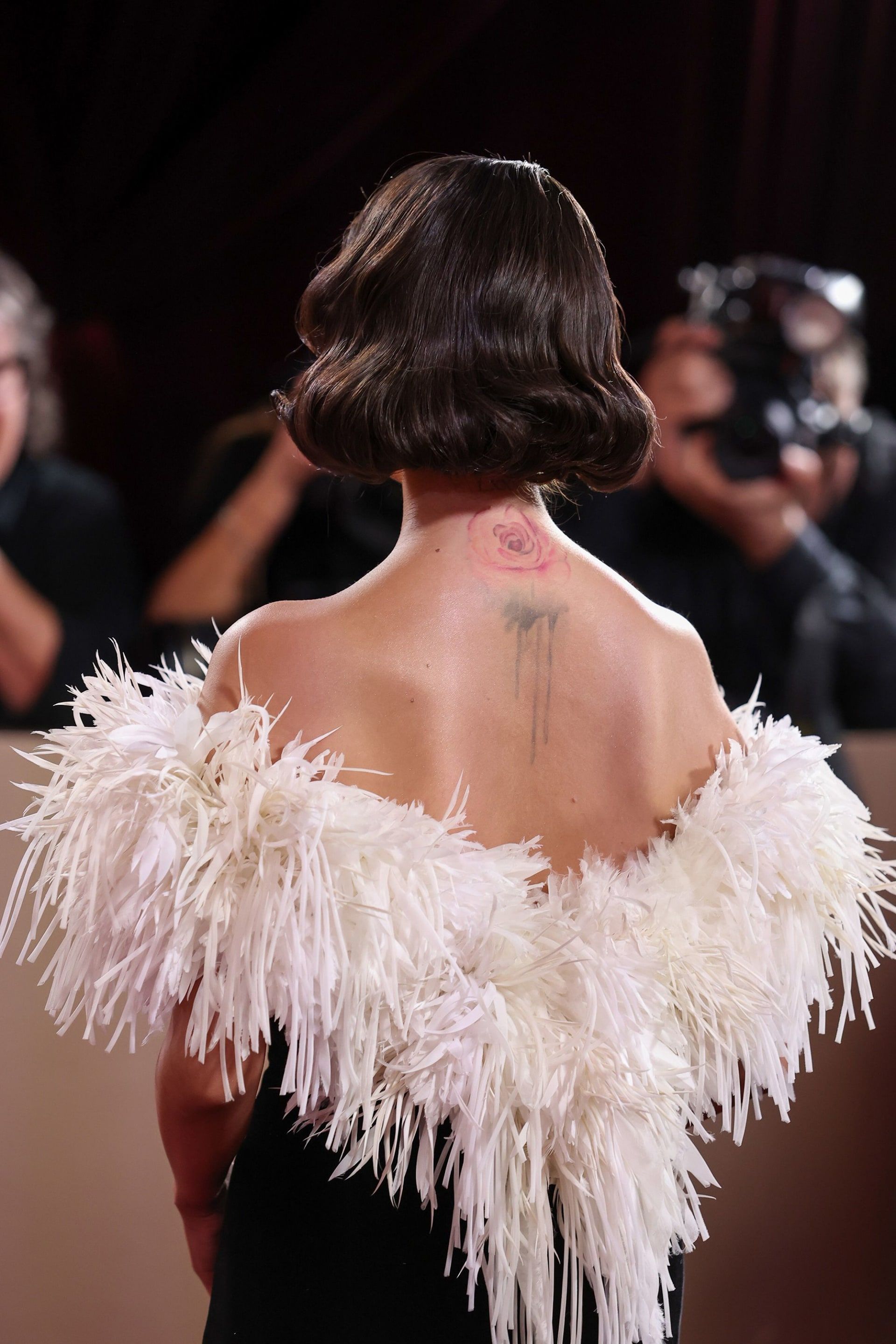 أظهر التصميم وشم الوردة على عنق غوميز من الخلف.