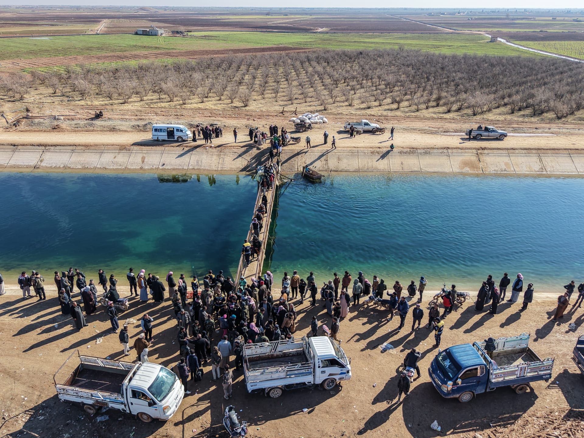 صورة جوية لأشخاص يفرون من منطقة تسيطر عليها القوات الكردية في رأس الحرمل، بريف حلب الشرقي، بالقرب من خط المواجهة مع قوات سوريا الديمقراطية بقيادة الأكراد في دير حافر، بتاريخ 16 يناير/كانون الثاني 2026، شرق حلب، سوريا.