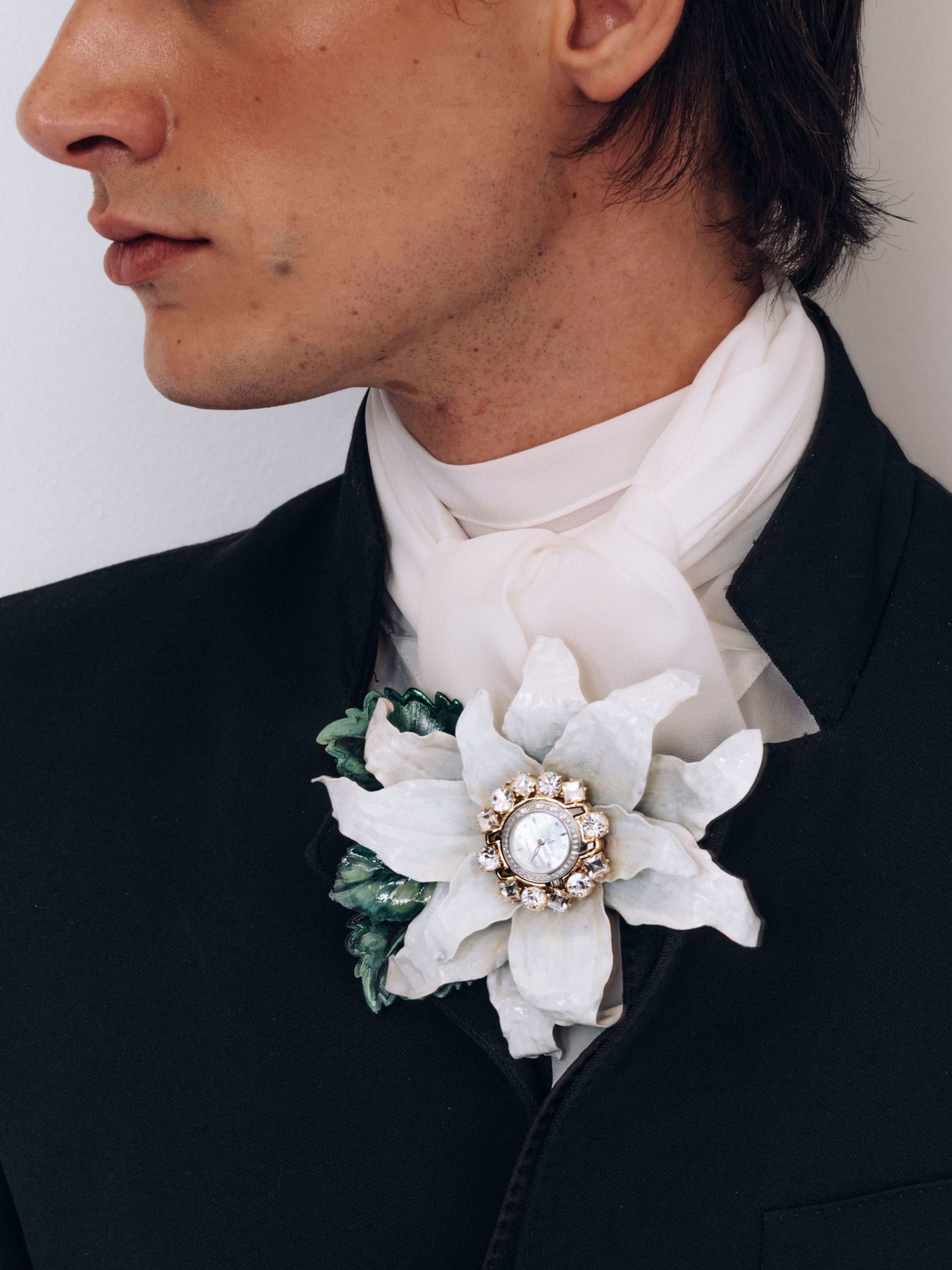 تزين دبوس أنيق من Dolce & Gabbana قلبه بساعة معقدة التصميم.