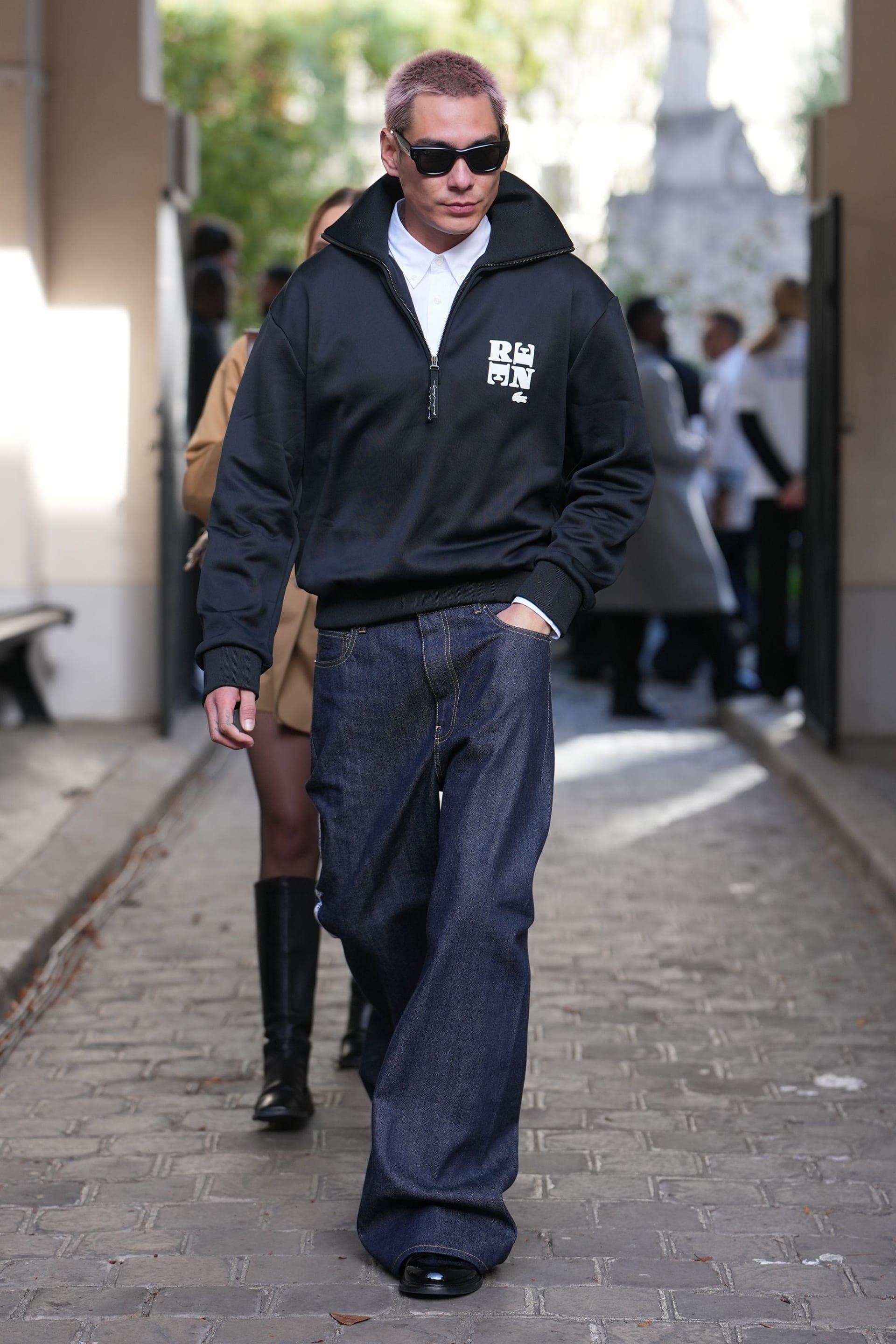 عارض الأزياء والممثل الأمريكي إيفان موك نسّق سويتشر نصف السحاب من لاكوست مع سروال جينز وحذاء جلدي أسود في أسبوع الموضة بباريس.