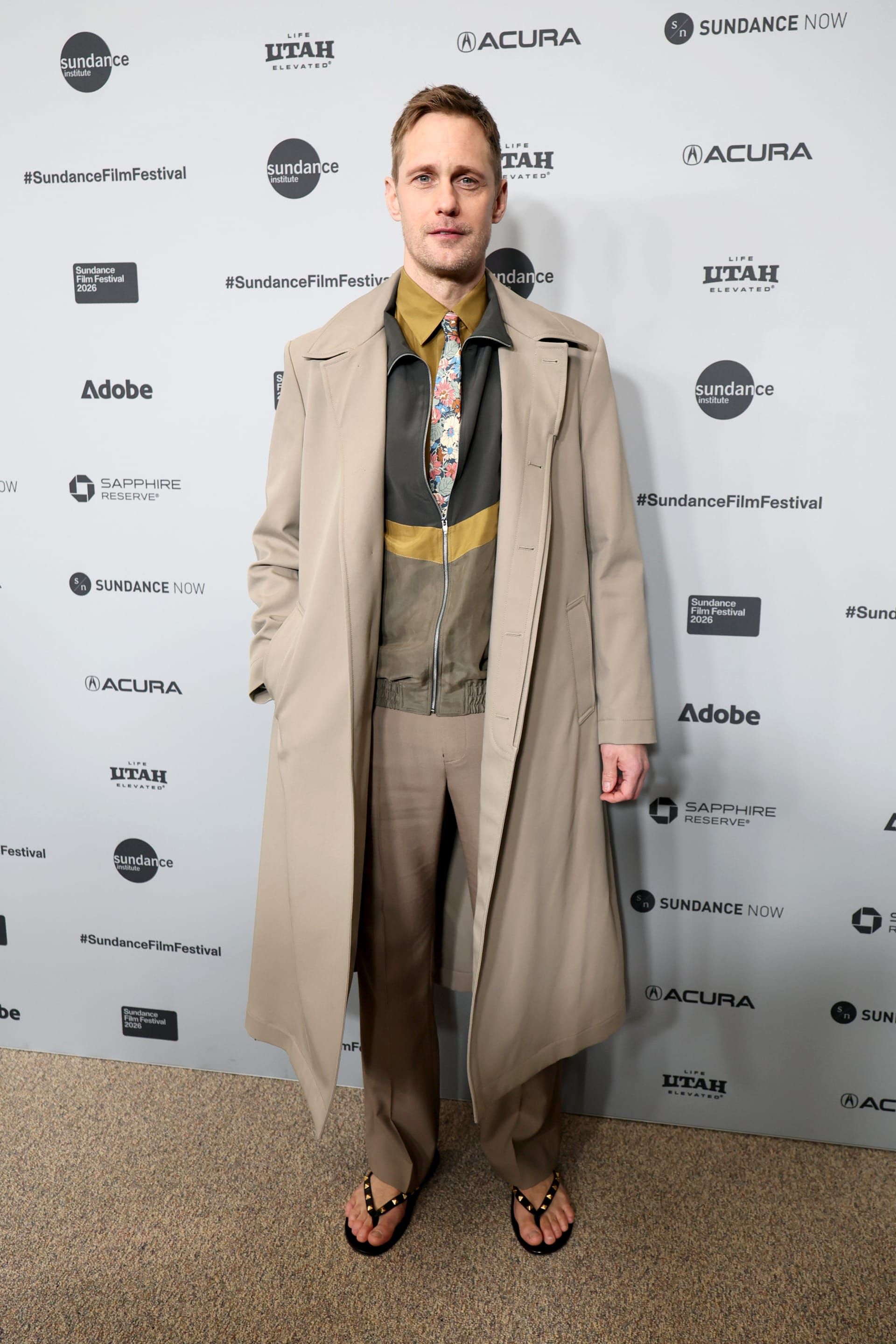 الممثل السويدي ألكسندر سكارسغارد يرتدي بدلة متعددة الطبقات والألوان.