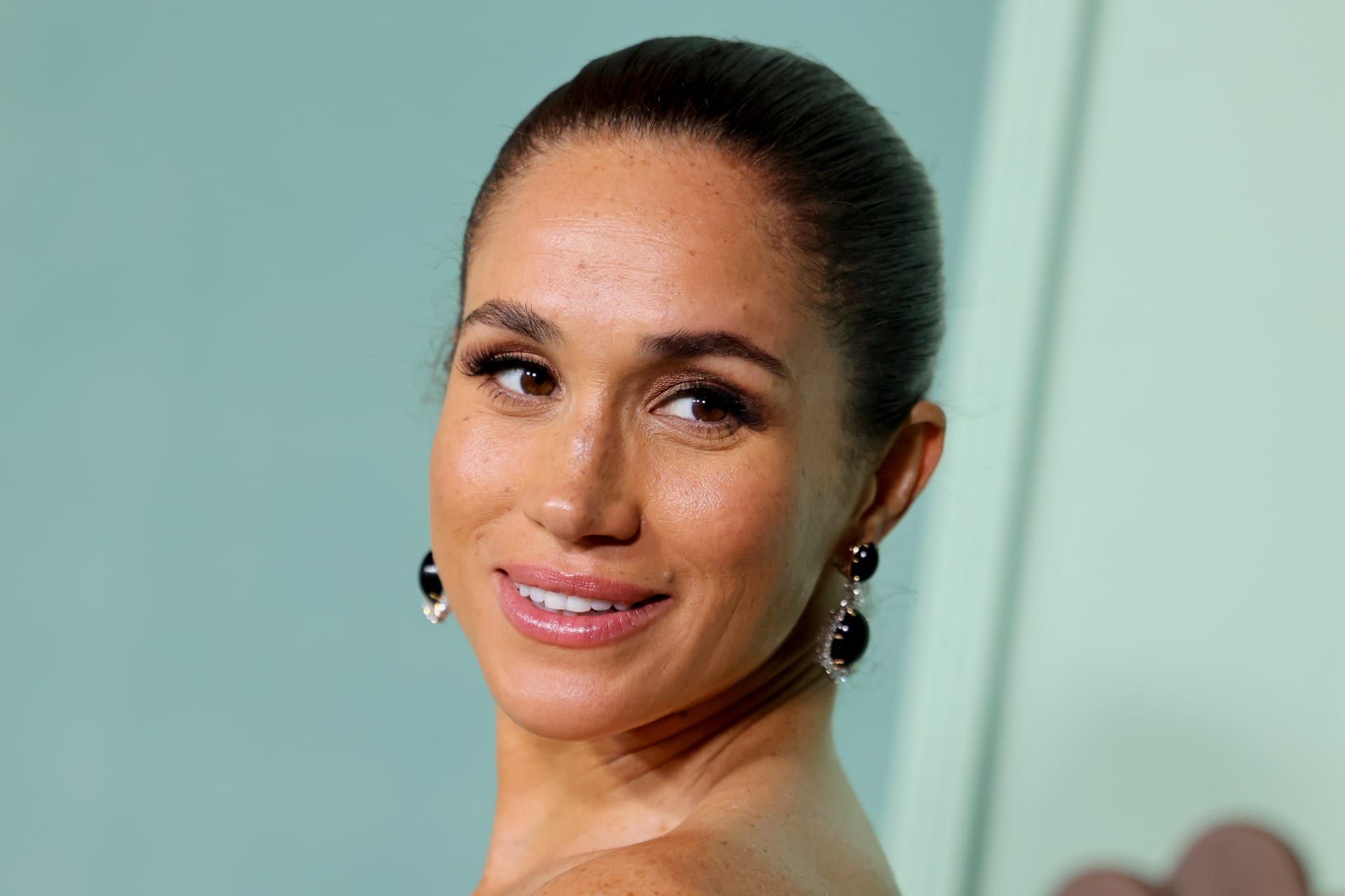 اكتملت الإطلالة بمكياج ناعم وكعكة شعر خلفيّة مشدودة.