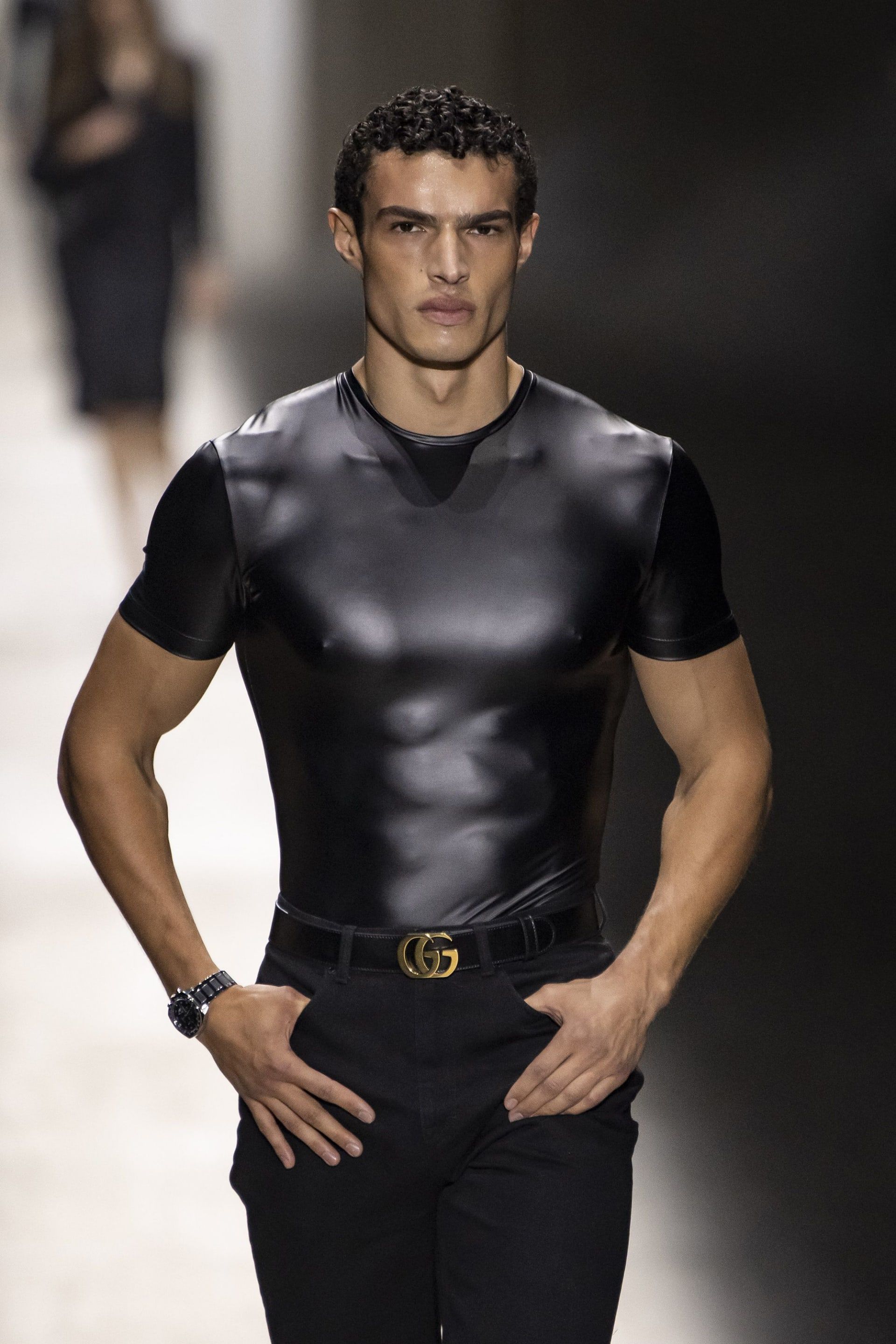 عارض أزياء مفتول العضلات يرتدي قميصًا ضيقًا جدًا.