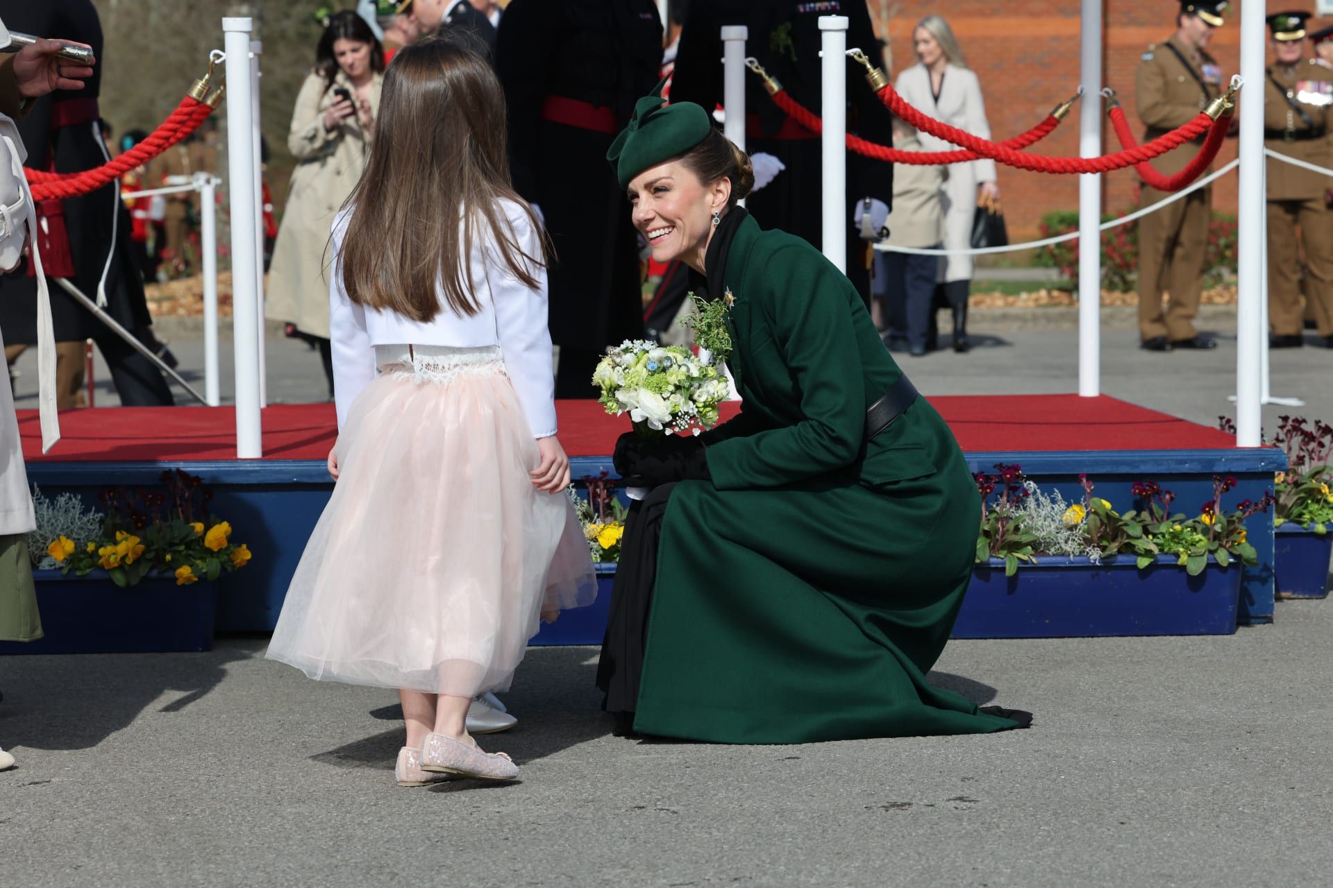 ميدلتون منحنية أمام طفلة قدّمت لها باقة من الأزهار خلال الحفل.
